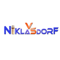 Das Logo zeigt den Schriftzug 'Niklas Dorf' in Blau, Rot und Orange. Ein kleiner brauner zylindrischer Gegenstand befindet sich in der Mitte von 'N' und 'K'.