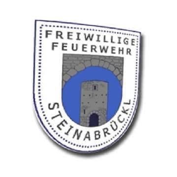 Das Emblem der Freiwilligen Feuerwehr Steinabruck zeigt ein Schloss in einem kreisförmigen Rahmen, mit den Worten 'Freiwillige Feuerwehr' darüber und 'Steinabruck' darunter.