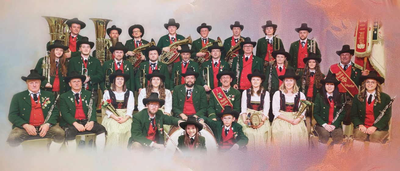 Eine Gruppe von Musikern in traditioneller bayerischer Kleidung, die für ein Foto mit verschiedenen Instrumenten wie Trompeten, Posaunen und Flöten posiert.