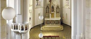 Ein Innenraum einer Kirche mit einem zentralen Altar, einem Kreuz und Buntglasfenstern. Der Altar ist von einer goldgeränderten Plattform umgeben. Drei Bänke sind in der Nähe platziert.