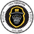 Ein rundes Emblem, das einen Gorilla in einem gelben Hut zeigt. Darauf steht 'Crew Twenty Six' über dem Gorilla und 'ESTD. 2023' darunter. Der Hintergrund ist ein Kettengliedmuster.