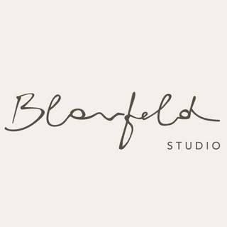 Das Bild zeigt das Logo für 'Blonfeld Studio', wobei 'Blonfeld' in Kurschrift und 'STUDIO' in Fettdruck darunter steht, vor einem hellgrauen Hintergrund.