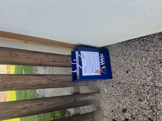 Ein blauer Weiz-Paket befindet sich auf den Holzgeländern einer Treppe, in der Nähe des Bodens.