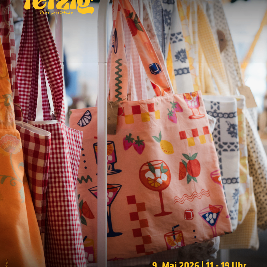 Eine Ausstellung von bunten Tragetaschen mit verschiedenen Obst- und Cocktaildesigns hängt an einem Ständer. Das Datum 9. Mai 2026 und die Zeit 11-19 sind unten sichtbar.