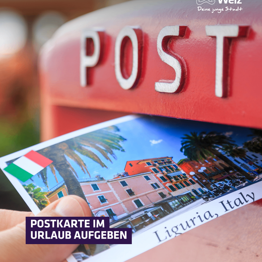 Eine Hand hält eine Postkarte mit einem Bild eines Gebäudes in Ligurien, Italien, und der italienischen Flagge. Die Postkarte wird in einen roten Briefkasten mit dem Wort 'POST' eingelegt.