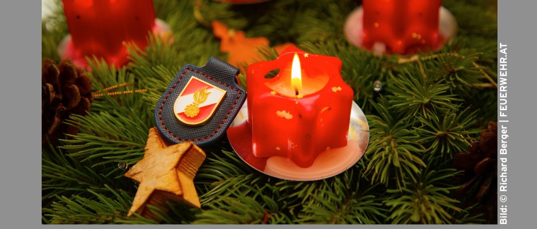 Ein Plakat zeigt einen Kranz mit roten Kerzen und einem Stern und verkündet, dass die Feuerwehrmänner von Hallein am 24. Dezember das Friedenslicht verteilen. Es gibt auch Zeiten für das Sammeln des Lichts in der Hauptwache und in Bad Dürrnberg an.