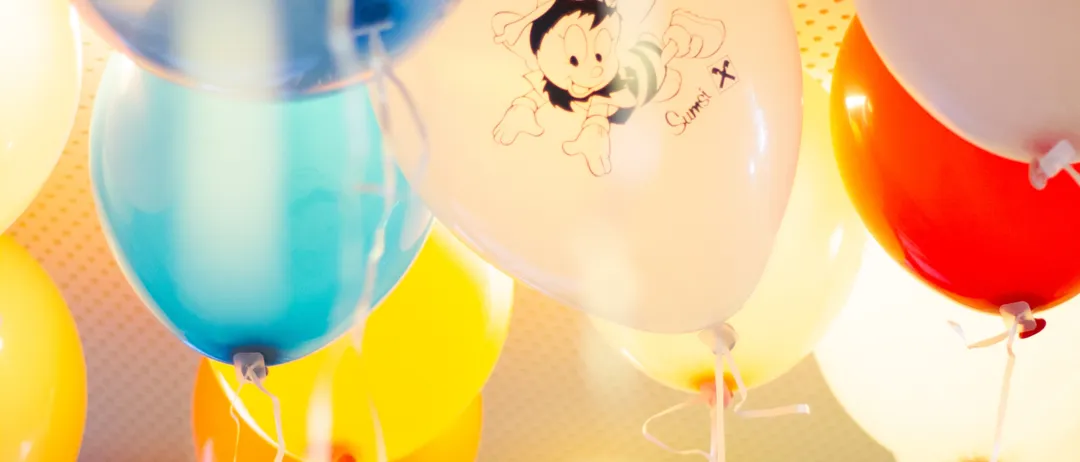 Eine Gruppe bunter Luftballons mit Comicfiguren darauf hängt an der Decke.