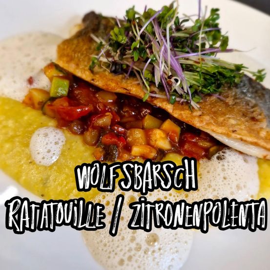 Ein Teller mit Wolfsbarsch Ratatouille mit Zitronenpolenta, garniert mit grünen Kräutern und einer lebhaften Mischung aus Gemüse. Das Gericht wird auf einem weißen Teller mit einer cremigen gelben Basis serviert.