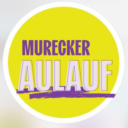 Ein gelber kreisförmiger Aufkleber mit weißem Rand. Er zeigt das Wort 'MURECCKER' in Lila oben und 'AULAUF' in Weiß unten.