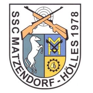 Ein Logo mit einem Schild, einem weißen Pferd, gekreuzten Gewehren, einem Zahnrad und dem Text 'SSG MATZENDORF-HOLES 1978'.