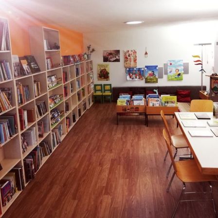 Bild enthält, Furniture, Bookcase, Architecture, Building, Book, Library, Publication, Chair, Wood, Person