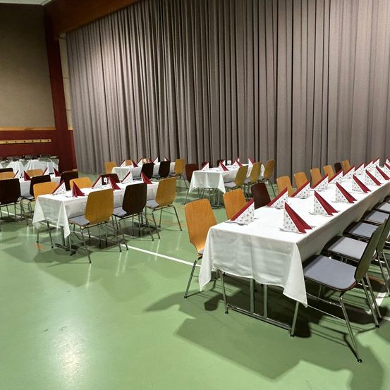 Bild enthält, Indoors, People, Person, Chair, Furniture, Hall, Building, Crowd, Classroom, Banquet