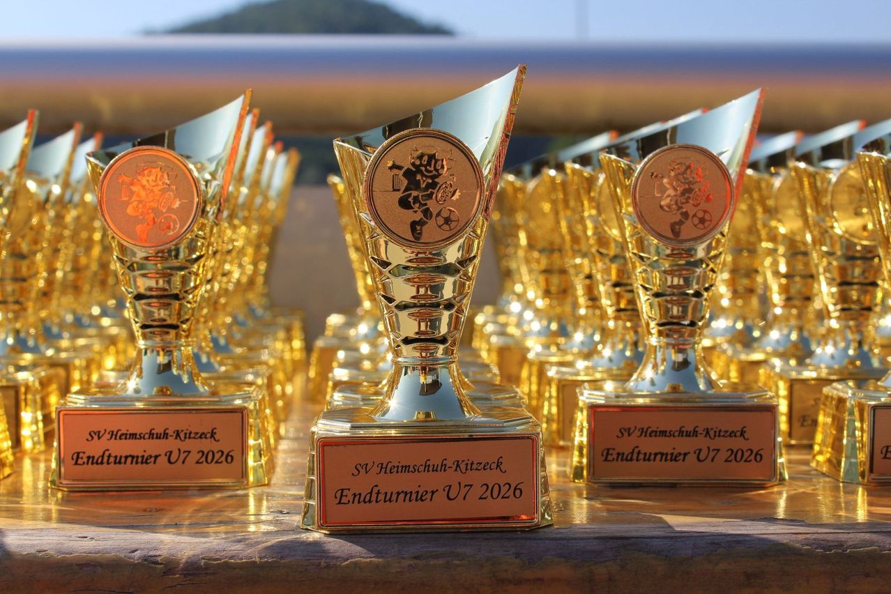 Goldene Trophäen mit dem Text Endturnier U7 2026 und SV Heimschuh-Kitzeck auf einem Holztisch.