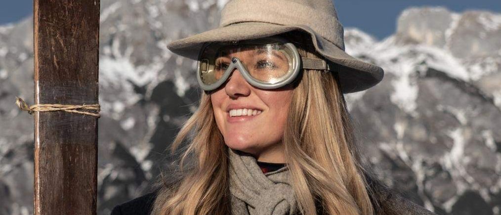 Eine lächelnde Frau in Hut und Schutzbrille hält einen Ski auf einem verschneiten Berg. Das Plakat bewirbt eine Skiveranstaltung am 14. März 2026 in Werfeng, Ladenberg.