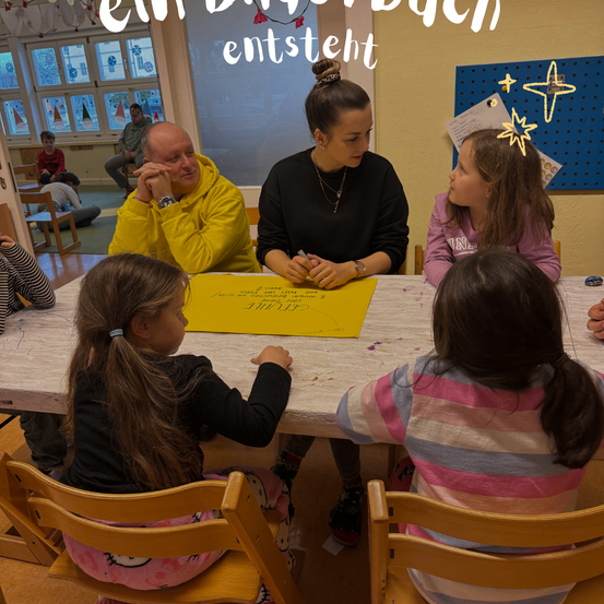 Eine Familie sitzt um einen Tisch in einem Klassenzimmer herum, mit einer Frau und drei Kindern. Die Frau liest ein gelbes Papier, während die Kinder aufmerksam zuhören.