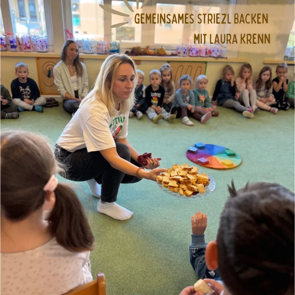 Eine Frau kniet und hält einen Teller mit Essen vor einer Gruppe von Kindern, die auf dem Boden sitzen.