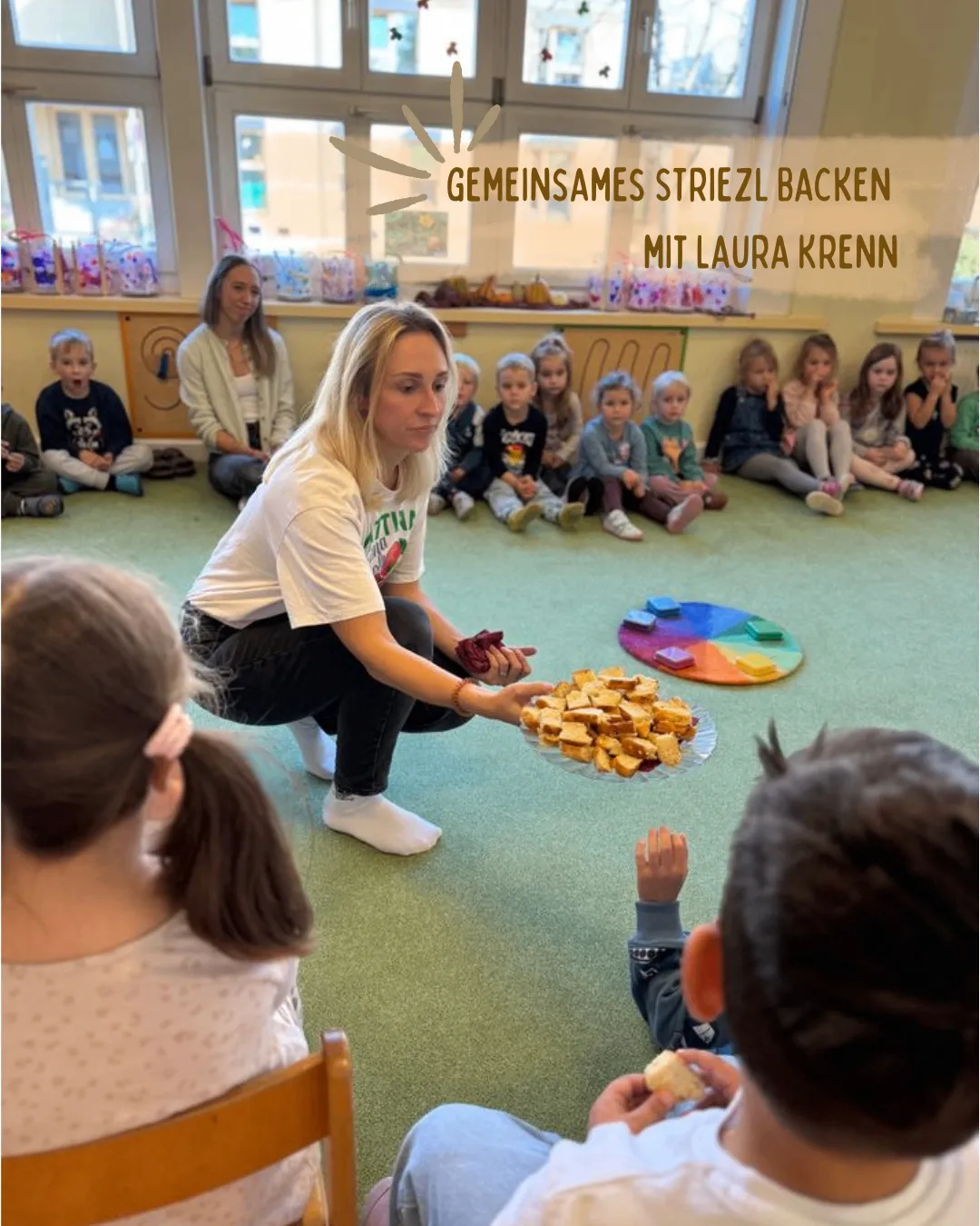 Eine Frau kniet und hält einen Teller mit Essen vor einer Gruppe von Kindern, die auf dem Boden sitzen.