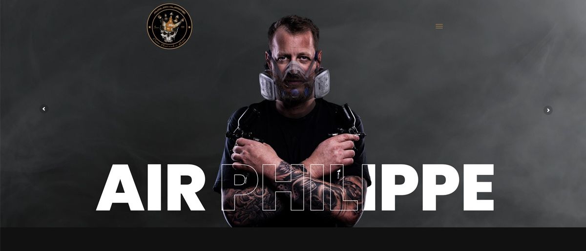 Ein Mann mit Tattoos und einer Maske posiert mit Airbrush-Pistolen. Über ihm stehen die Worte 'AIR PHILIPP' in weiß. Unten steht 'Air-Philippe - dein Airbrush-Künstler aus Glognitz'.