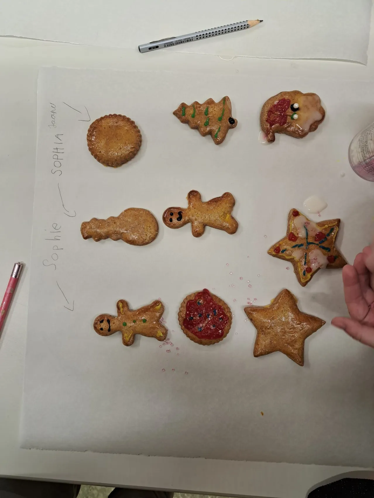 Eine Sammlung von Lebkuchenplätzchen ist auf einer weißen Oberfläche angeordnet, einschließlich Lebkuchenmänner, eines Sterns und eines Weihnachtsbaums.
