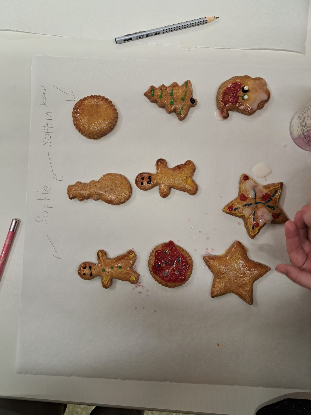 Eine Sammlung von Lebkuchenplätzchen ist auf einer weißen Oberfläche angeordnet, einschließlich Lebkuchenmänner, eines Sterns und eines Weihnachtsbaums.