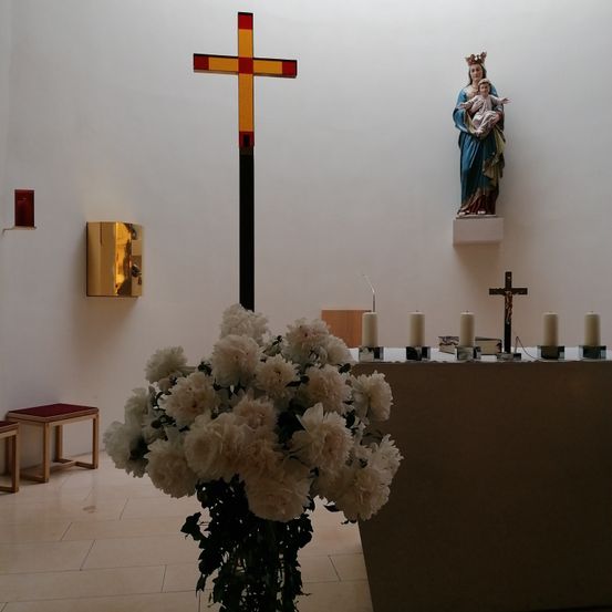 Bild enthält, Flower, Flower Arrangement, Plant, Flower Bouquet, Cross, Symbol, Altar, Person, Floor, Candle