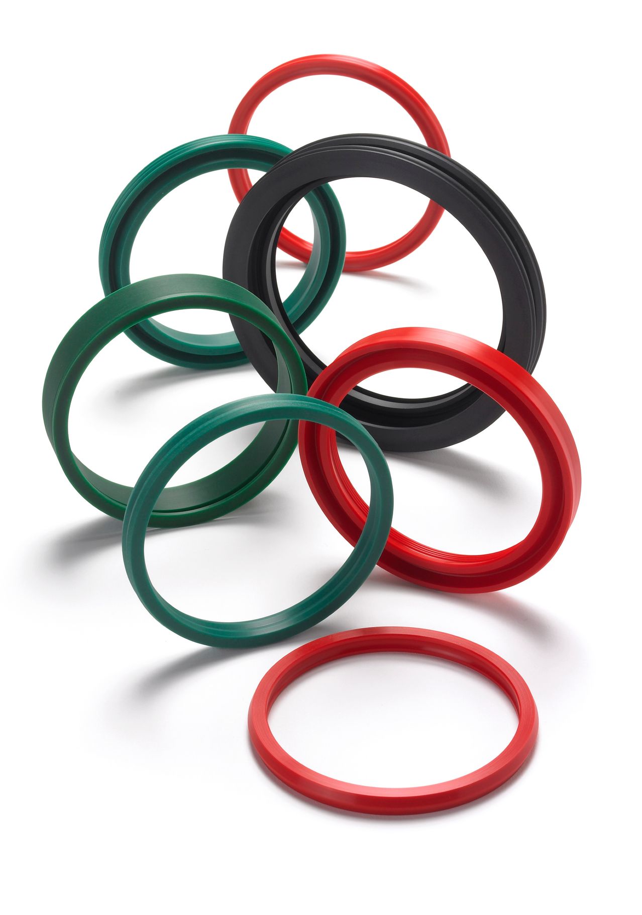 Sechs Gummidichtungen in verschiedenen Farben, einschließlich Grün, Schwarz und Rot, auf einer weißen Oberfläche angeordnet.