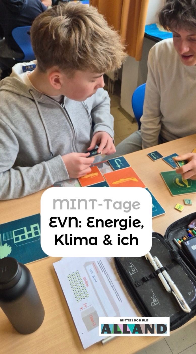 Two people sit at a table playing a game with cards, one person holding a game piece. There is a text overlay with the words 'MINT-Tage EVN: Energie, Klima & ich'.