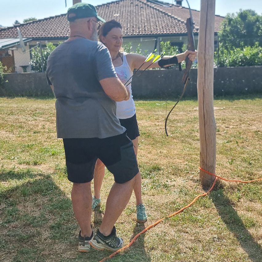 Bogenschützin trainiert mit Trainer auf einem sonnigen Feld in Österreich