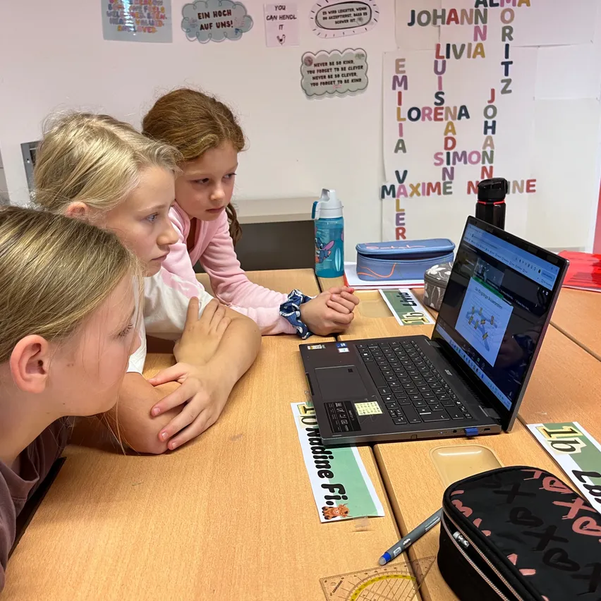 Schülerinnen lernen an einem Laptop in einem Klassenzimmer in Österreich.