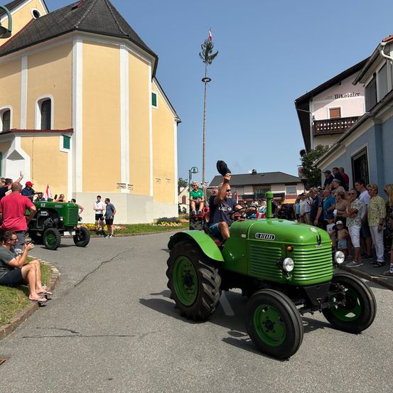 Bild enthält, Neighborhood, Wheel, Adult, Male, Man, Person, Tractor, Vehicle, Shelter, Car