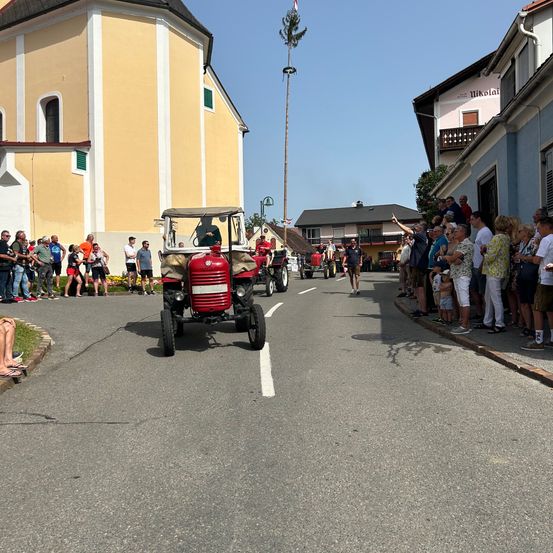 Bild enthält, Neighborhood, City, Road, Street, Antique Car, Model T, Vehicle, Wheel, Person, Building