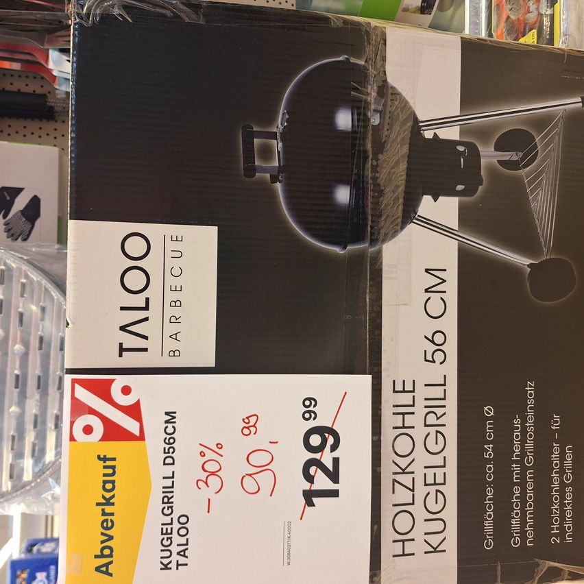 A box of a Taloo brand charcoal barbecue grill, 56 cm in diameter, with a price tag showing a discount from 99 to 129.99.