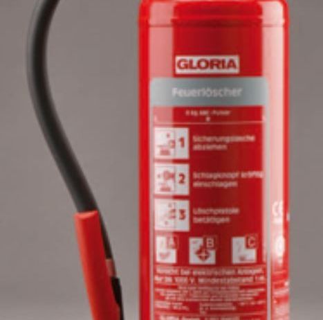 Ein roter Feuerlöscher mit der Aufschrift Gloria, schwarzem Schlauch und Griff. Er hat ein Fassungsvermögen von 6 kg und ein Sicherheitsetikett mit Symbolen und Text.