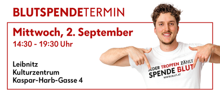 Ein lächelnder Mann zeigt auf ein weißes T-Shirt mit dem Text 'Jeder Tropfen zahlt Spende Blut' und einer Website-Adresse. Der Hintergrund ist weiß mit rotem Text. Der Mann steht vor einem roten Rand.