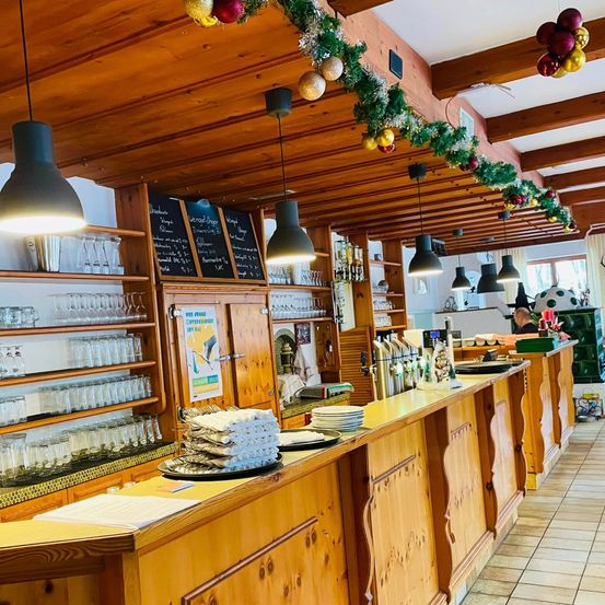 Bild enthält, Indoors, Interior Design, Hardwood, Stained Wood, Wood, Chair, Furniture, Person, Lamp, Blackboard