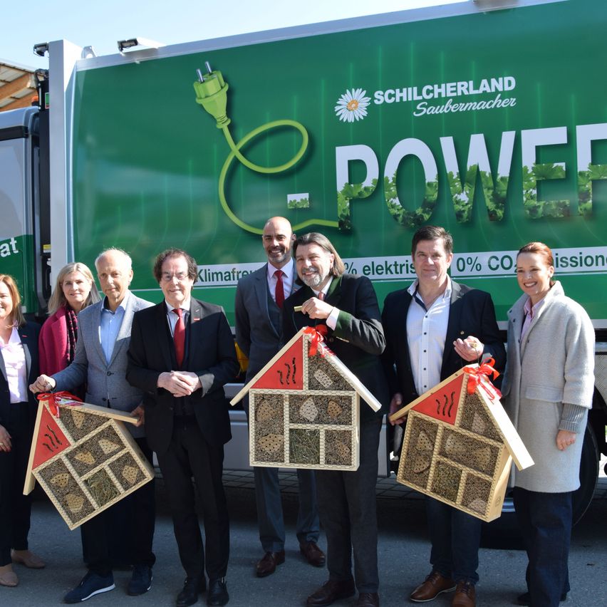 Mehrere Menschen in Anzügen halten Boxen vor einem Schilcherland-Lkw. Der Lkw hat eine Werbung für elektrische Energie.