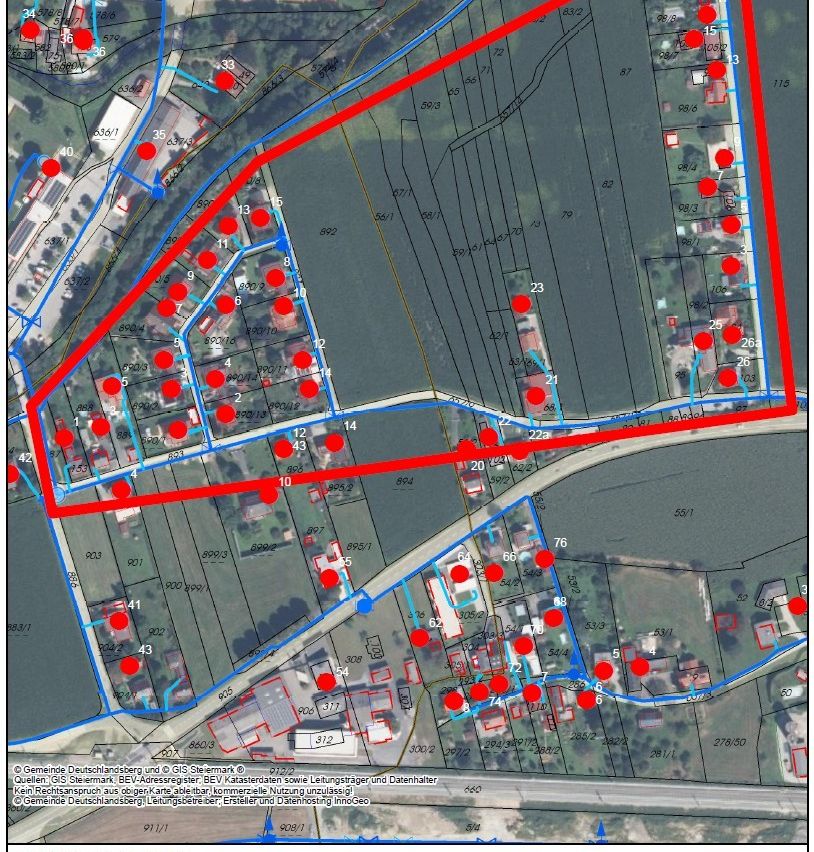 Eine Karte mit verschiedenen nummerierten Grundstücken, einige mit roten Markierungen. Eine rote Linie begrenzt einen Bereich, wahrscheinlich eine Grenze. Wassermerkmale sind sichtbar. Nummern und Grundstücksreferenzen sind über die Karte verstreut.
