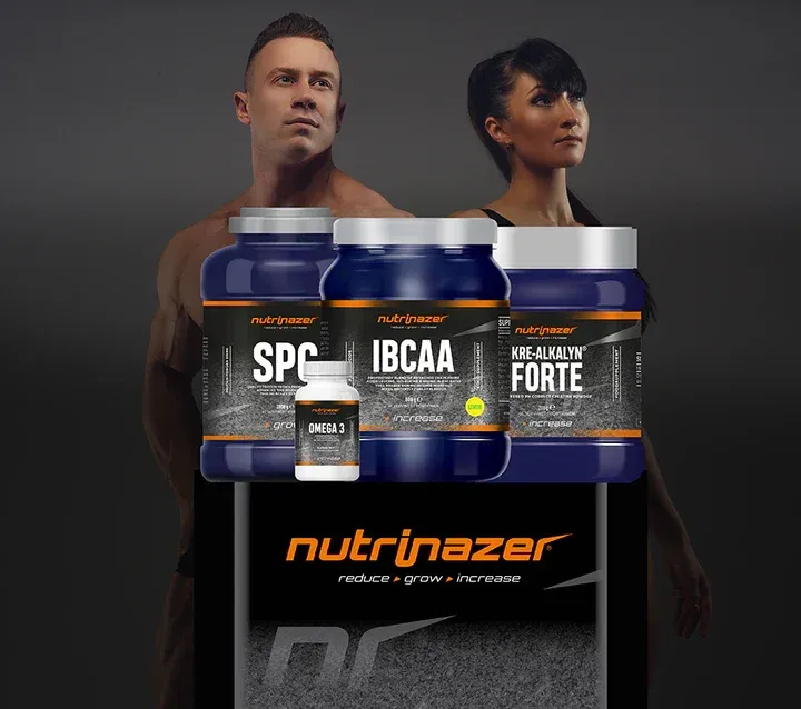 Ein Mann und eine Frau stehen hinter mehreren blauen Flaschen mit Nahrungsergänzungsmitteln. Die Flaschen sind mit SPC, IBCA und KRE-ALKALYN FORTE beschriftet. Es gibt auch eine weiße Flasche mit der Aufschrift OMEGA 3.