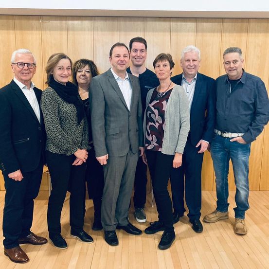 Bild enthält, Groupshot, Person, Adult, Female, Woman, Male, Man, Coat, Necklace, Suit