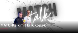 Ein Mann steht vor einem grauen Hintergrund mit weißen und schwarzen Buchstaben. Das Wort Match Talk ist in weißen Buchstaben geschrieben. Der Mann trägt ein weißes T-Shirt mit mehreren Aufklebern. Das Gesicht des Mannes wird von einem Licht beleuchtet.