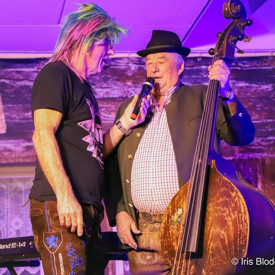 Bild enthält, Adult, Male, Man, Person, Concert, Face, Microphone, Group Performance, Musical Instrument, Hat