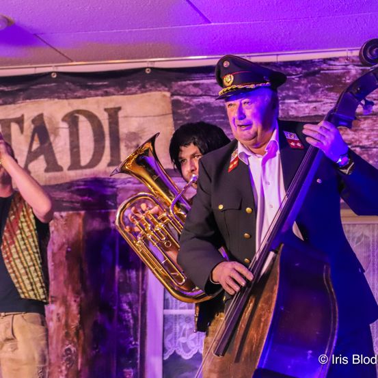 Bild enthält, Adult, Male, Man, Person, Brass Section, Horn, Musical Instrument, Tuba, Group Performance, Face