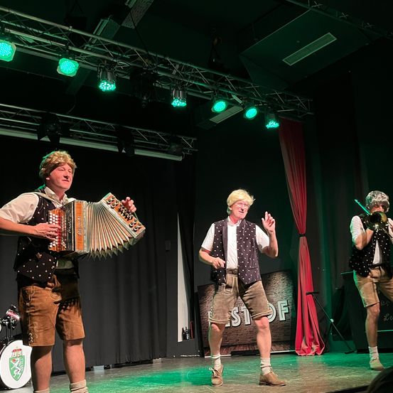 Bild enthält, Adult, Male, Man, Person, Group Performance, Stage, Musical Instrument, Performer, Singing, Shorts