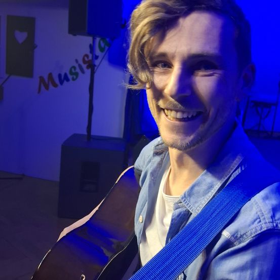 Bild enthält, Adult, Male, Man, Person, Guitar, Musical Instrument, Face, Head, Guitarist, Smile