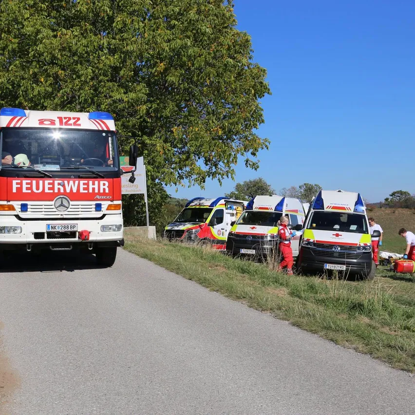 Ein Krankenwagen ist am Straßenrand geparkt, in der Nähe ein Feuerwehrauto.