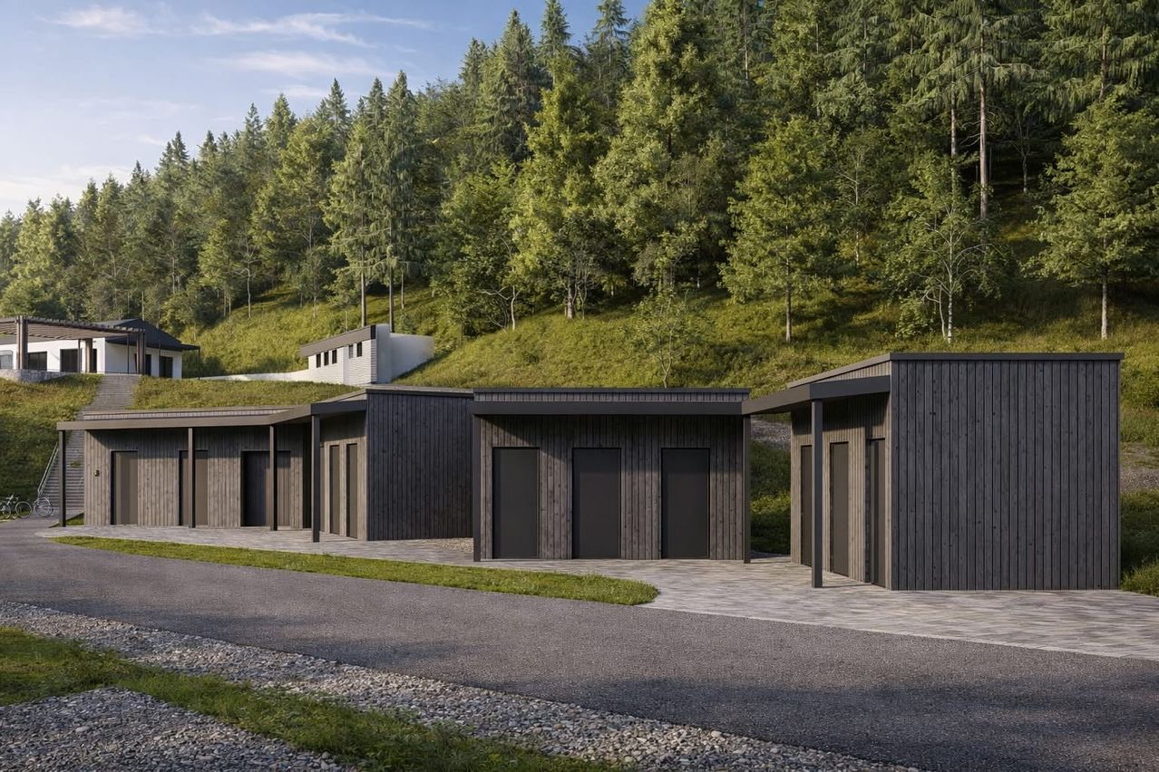 A rendering of a modern architectural design featuring a row of dark-colored buildings with large windows and doors, set against a backdrop of lush green hills and trees.