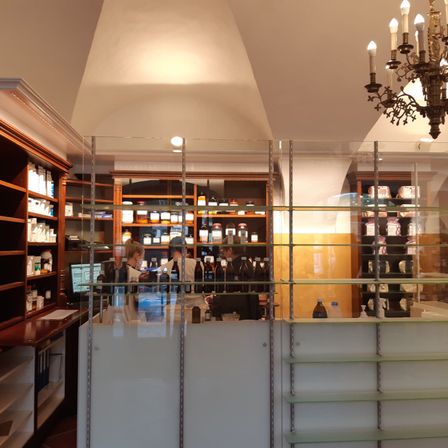 Bild enthält, Chandelier, Lamp, Person, Shop, Liquor, Indoors, Interior Design, Wine Cellar