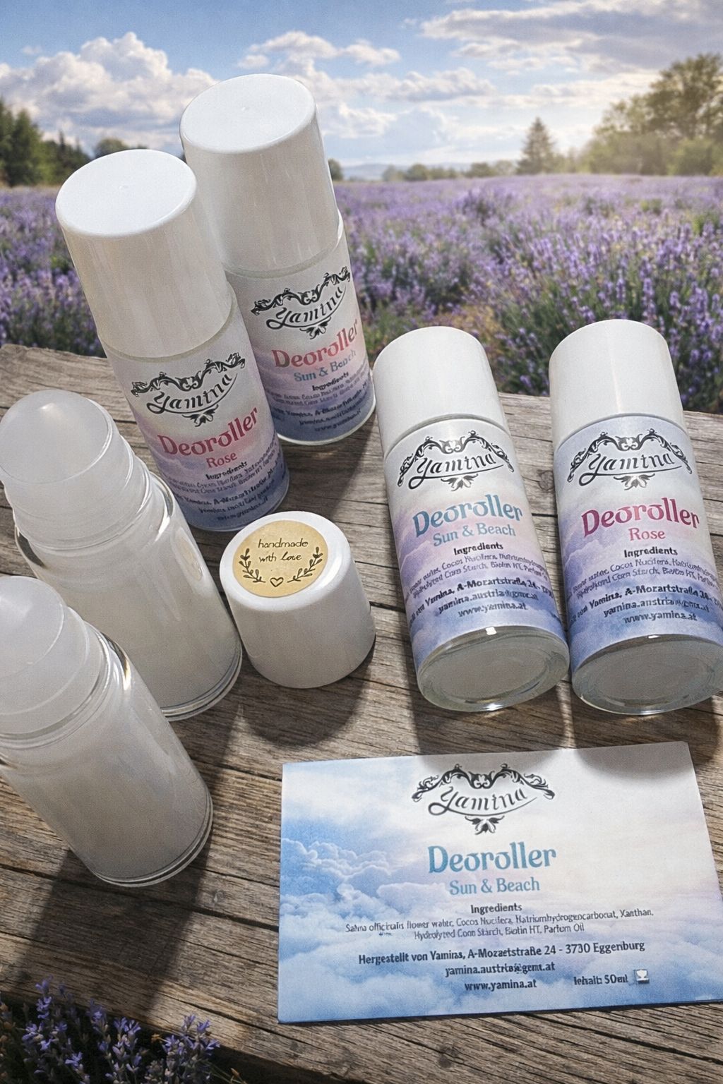 Several bottles of 'Deorolller' and 'Yamina' products on a wooden surface with lavender in the background. There are bottles of 'Deorolller' in different flavors like rose and sun & beach.