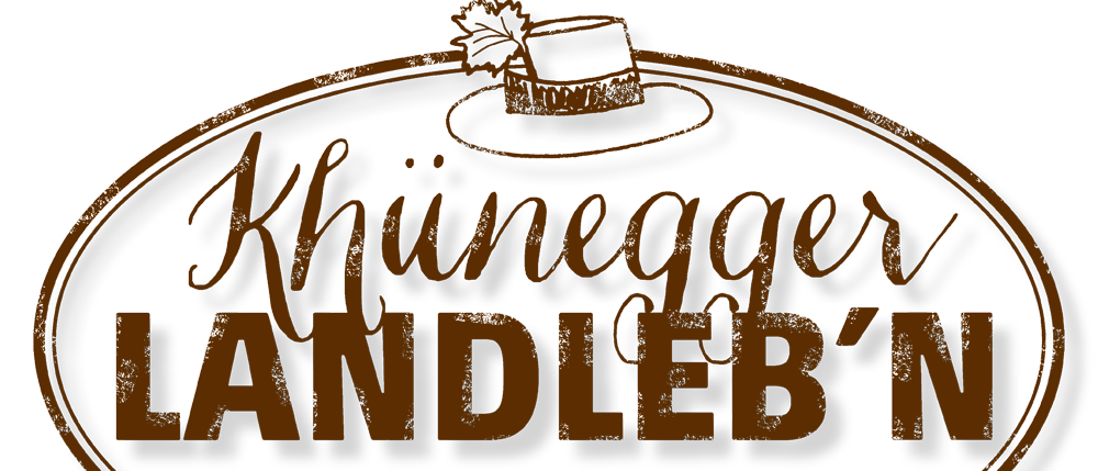 Das Logo von Khiunegger Candle zeigt einen braunen Hut mit einem Blatt oben, vor einem schwarzen Hintergrund mit goldenen Verzierungen.