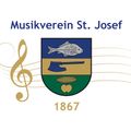 Das Emblem des 1867 gegründeten Musikverein St. Josef zeigt einen Violinschlüssel, einen Fisch, eine Axt, Mais und einen Apfel auf einem Schild.